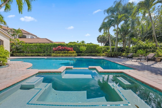 view of pool featuring a patio area and an in ground hot tub