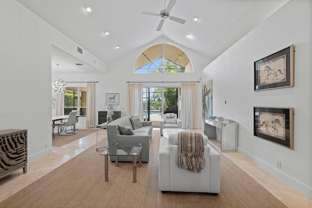 living room featuring a wealth of natural light, ceiling fan with notable chandelier, and lofted ceiling