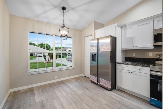 kitchen with light hardwood / wood-style floors, white cabinetry, appliances with stainless steel finishes, decorative light fixtures, and a chandelier