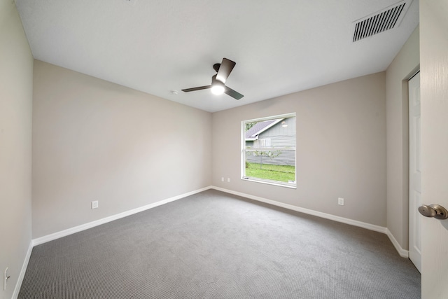 spare room featuring ceiling fan and dark carpet