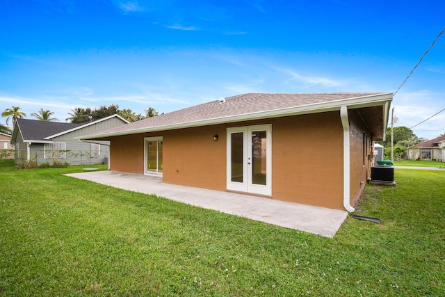 rear view of property with central air condition unit, a lawn, a patio, and french doors