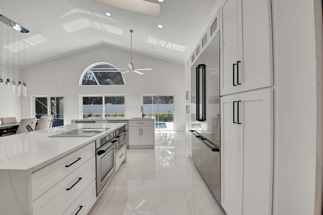 kitchen with ceiling fan, stainless steel oven, and white cabinetry