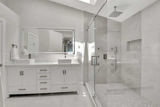 bathroom with vanity, a skylight, a shower with shower door, and tile patterned flooring