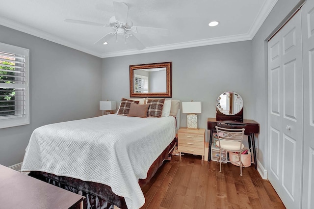 bedroom featuring dark wood-type flooring, a closet, ceiling fan, and ornamental molding