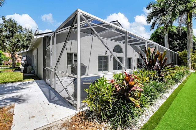 view of property exterior with a lanai and a lawn