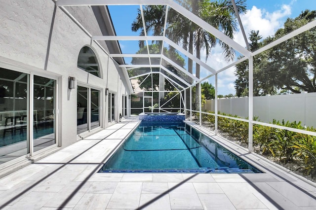 view of swimming pool with glass enclosure and a patio area