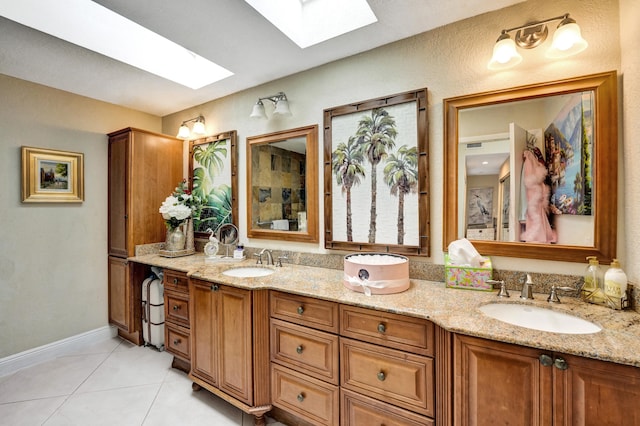 bathroom with tile patterned flooring, vanity, and a skylight