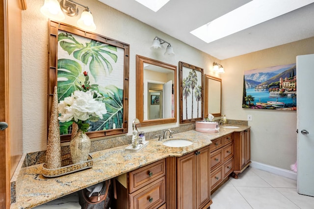 bathroom with vanity, a skylight, and tile patterned floors