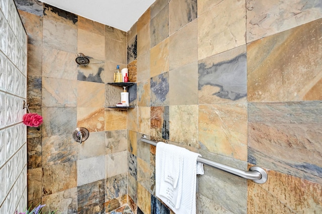 bathroom with a tile shower and tile walls