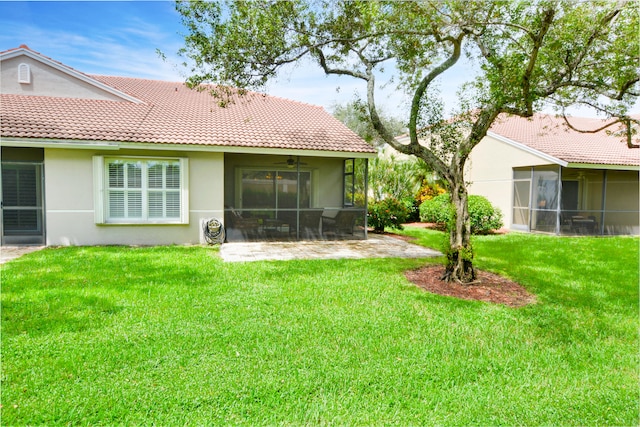 rear view of property featuring a yard and a sunroom