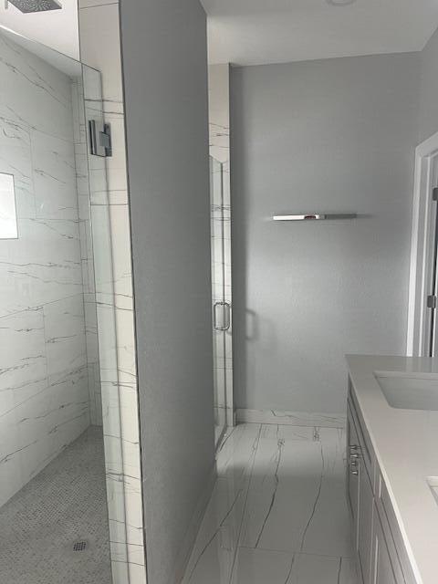 bathroom featuring walk in shower and vanity