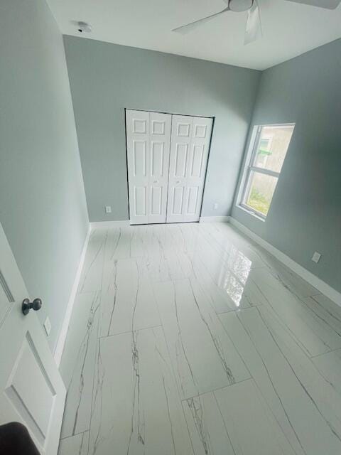 unfurnished bedroom with ceiling fan and a closet