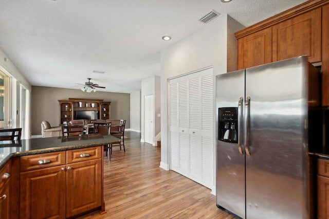 kitchen featuring light wood-type flooring, stainless steel fridge, a textured ceiling, and ceiling fan