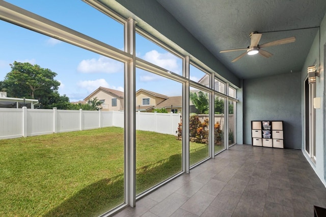 unfurnished sunroom featuring ceiling fan