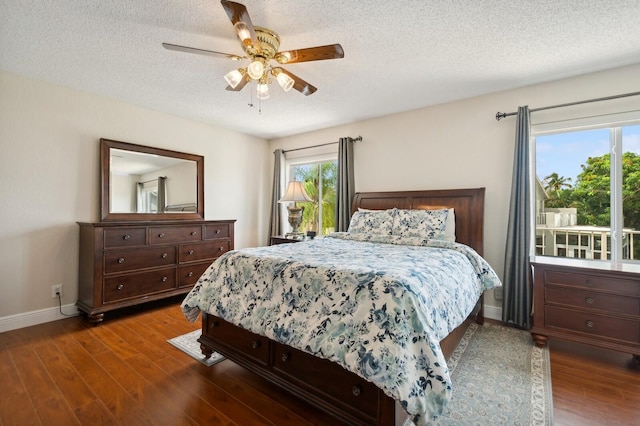 bedroom featuring a textured ceiling, dark wood-type flooring, and ceiling fan