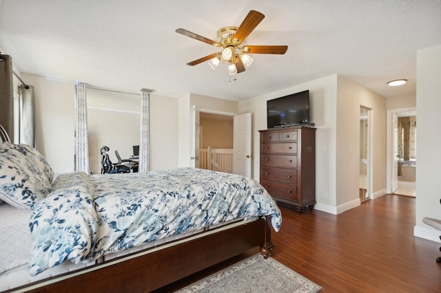 bedroom with a textured ceiling, connected bathroom, ceiling fan, and dark hardwood / wood-style floors