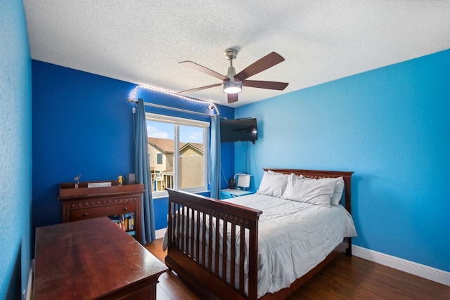 bedroom with ceiling fan, dark hardwood / wood-style flooring, and a textured ceiling