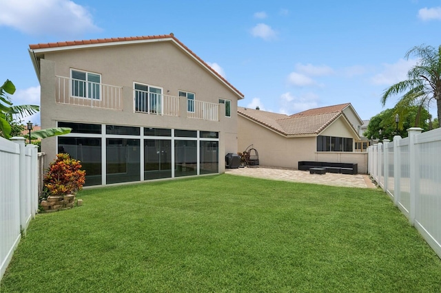 rear view of house with a yard and a patio area