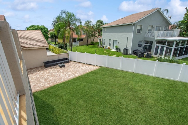 view of yard featuring central AC unit, a patio, and a balcony