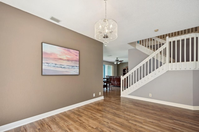 interior space featuring ceiling fan with notable chandelier and wood-type flooring