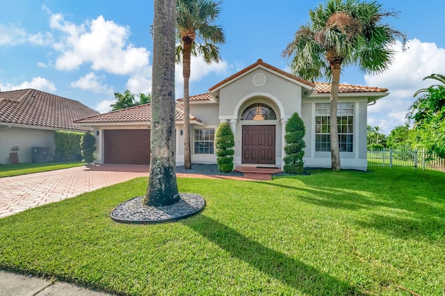 mediterranean / spanish house featuring a garage and a front yard