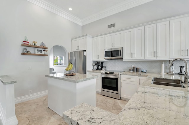 kitchen with a kitchen island, tasteful backsplash, stainless steel appliances, sink, and white cabinets