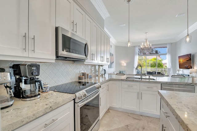 kitchen with an inviting chandelier, stainless steel appliances, sink, and white cabinetry