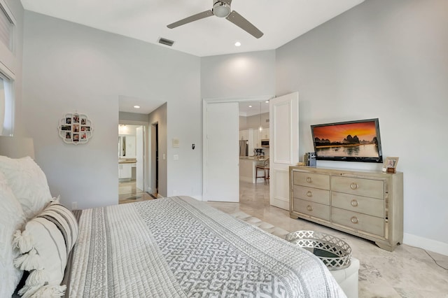 bedroom featuring stainless steel fridge, ceiling fan, connected bathroom, and a towering ceiling