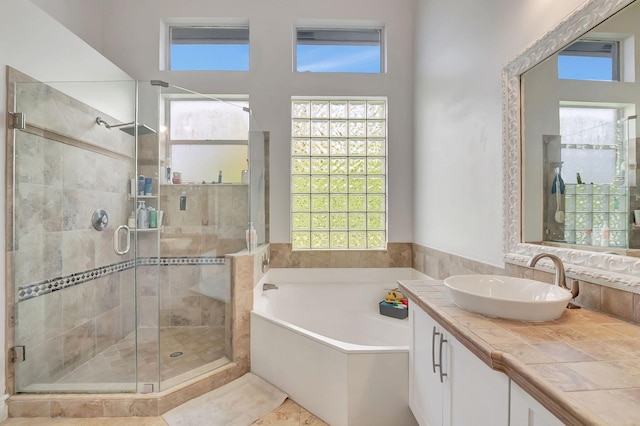 bathroom featuring plus walk in shower, a wealth of natural light, and vanity