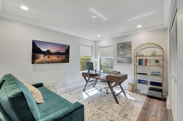 office space with ornamental molding, a textured ceiling, and light hardwood / wood-style floors