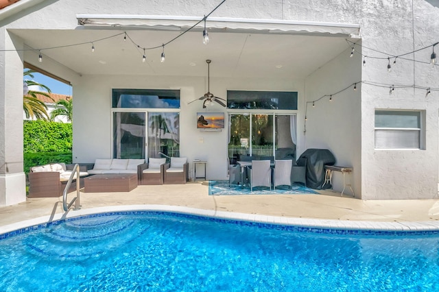 outdoor pool with an outdoor living space, area for grilling, and a patio