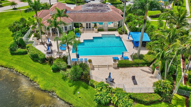 view of swimming pool with a water view, a lawn, and a patio area