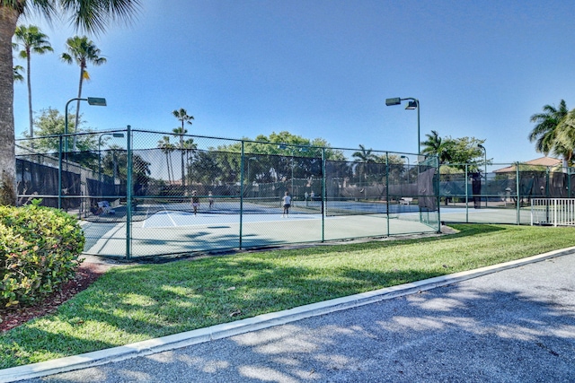 view of sport court featuring a lawn and fence