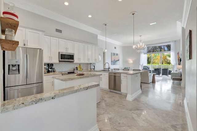 kitchen with stainless steel appliances, a chandelier, white cabinetry, sink, and kitchen peninsula