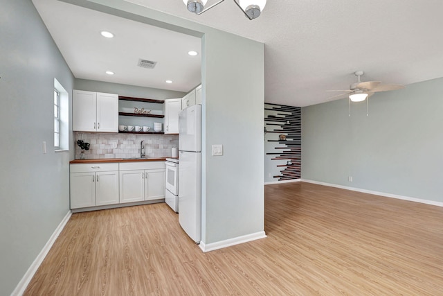 kitchen with white appliances, white cabinetry, light hardwood / wood-style flooring, butcher block counters, and ceiling fan