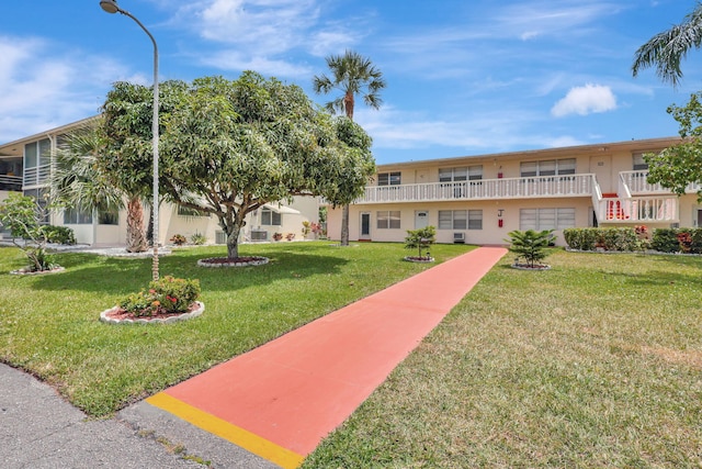 view of front of home featuring a balcony and a front yard