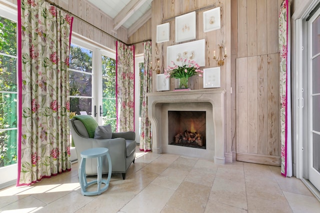 sitting room with wood walls and lofted ceiling with beams