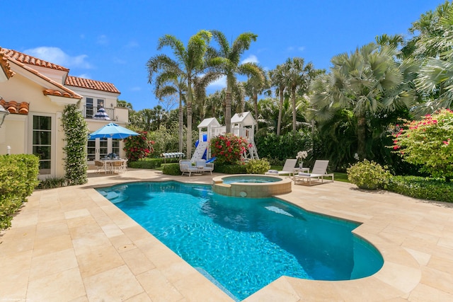 view of swimming pool with a patio area and an in ground hot tub