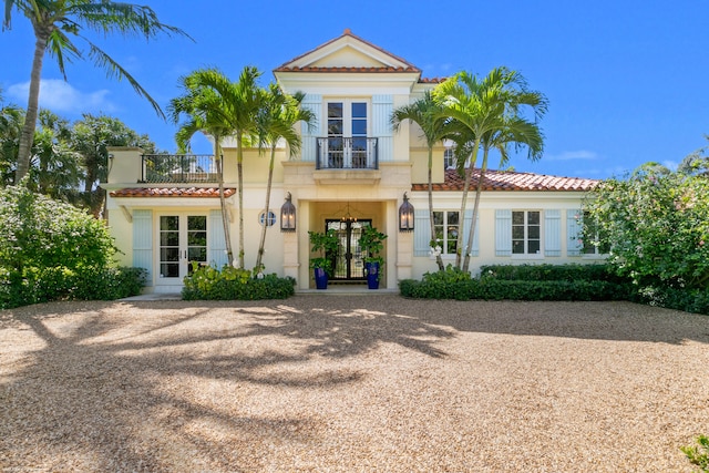 view of front of house with a balcony and french doors