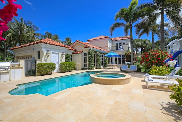 view of pool with a grill, a patio, and an in ground hot tub