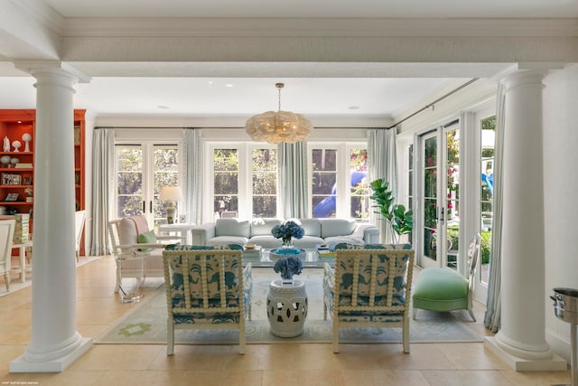 sunroom with a healthy amount of sunlight, a notable chandelier, and decorative columns