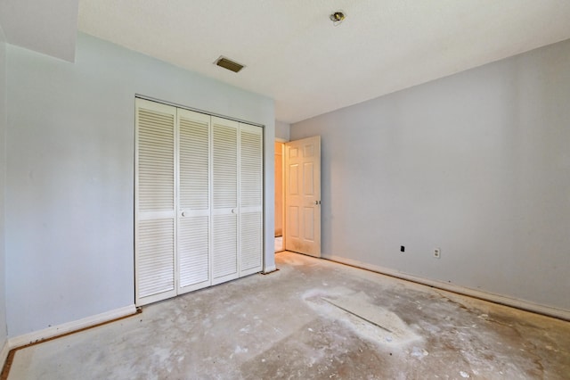 unfurnished bedroom featuring concrete floors and a closet