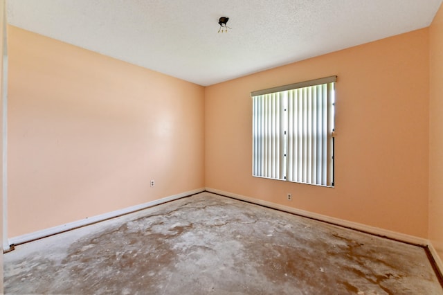 unfurnished room with concrete floors and a textured ceiling