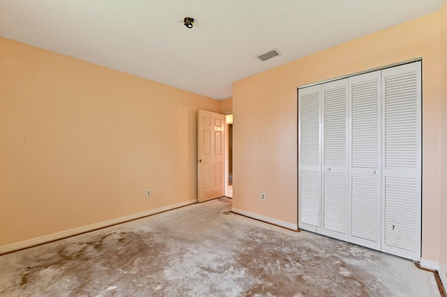 unfurnished bedroom featuring a closet and concrete flooring