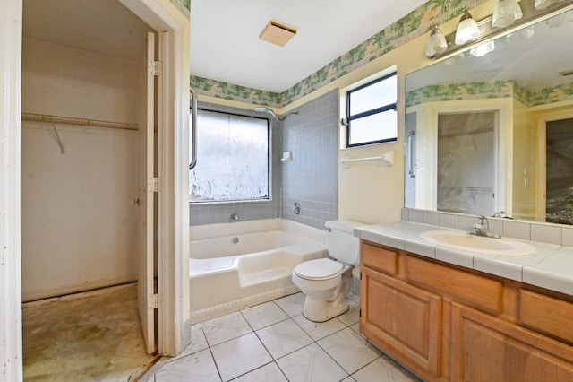 bathroom with vanity, a bathtub, tile patterned floors, and toilet