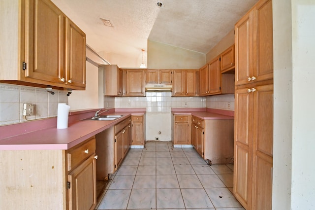 kitchen with sink, light tile patterned flooring, backsplash, a textured ceiling, and vaulted ceiling