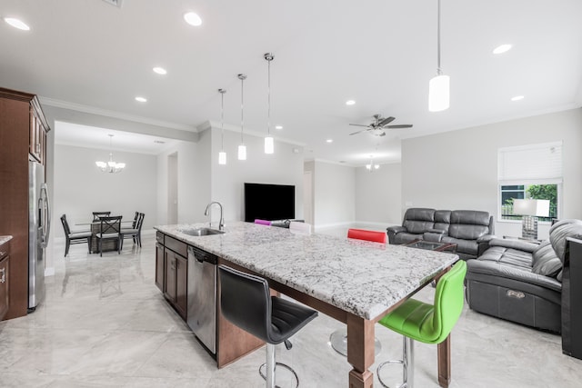 kitchen with ceiling fan with notable chandelier, sink, hanging light fixtures, appliances with stainless steel finishes, and a center island with sink