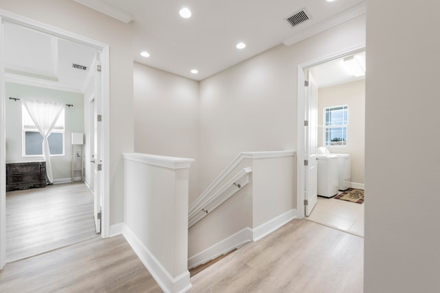 hall featuring ornamental molding and light hardwood / wood-style flooring