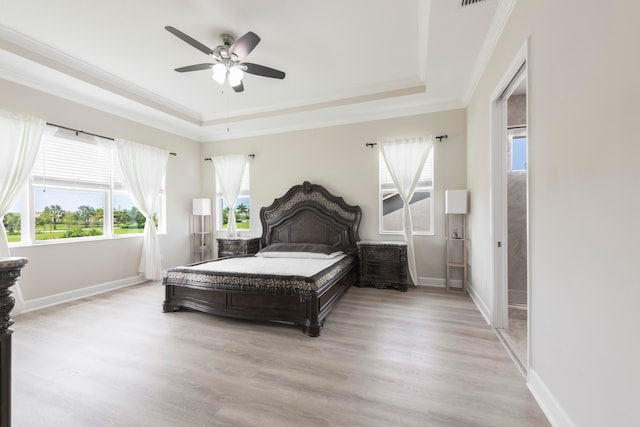 bedroom featuring crown molding, light hardwood / wood-style flooring, ceiling fan, and a raised ceiling