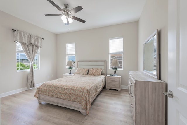 bedroom with light wood-type flooring, multiple windows, and ceiling fan